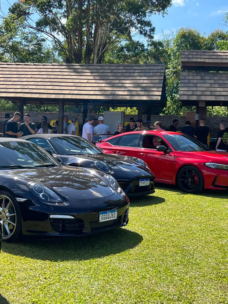 Porsches expostos na grama sob a cobertura de madeira, em uma edição anterior